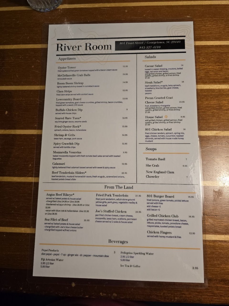 Restaurant menu beside a drink glass.